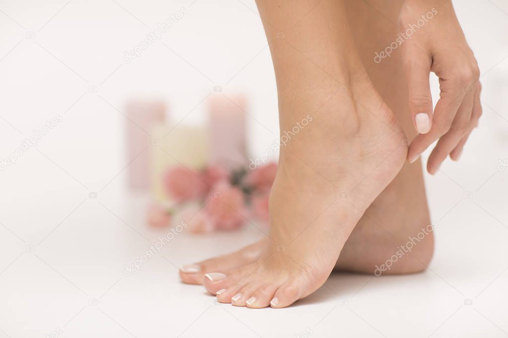 Woman touching her heels. Manicure and pedicure picture.