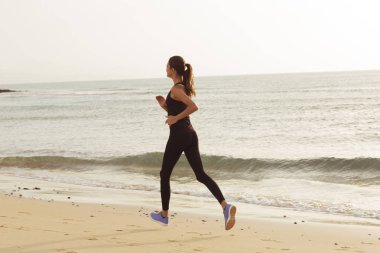 Sabah sahilde çalışan genç spor kadın.