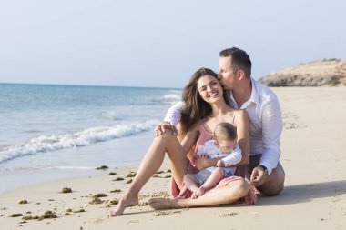 İyi görünümlü, Genç aile kumsalda güzel vakit harcama.