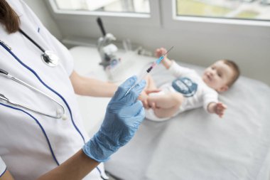 Bir enjeksiyon veren genç, kadın doktor. 