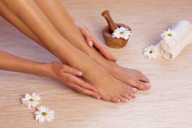 İdeal yapılan manikür ve pedikür resmi. Kadın ellerde ve spa noktada.