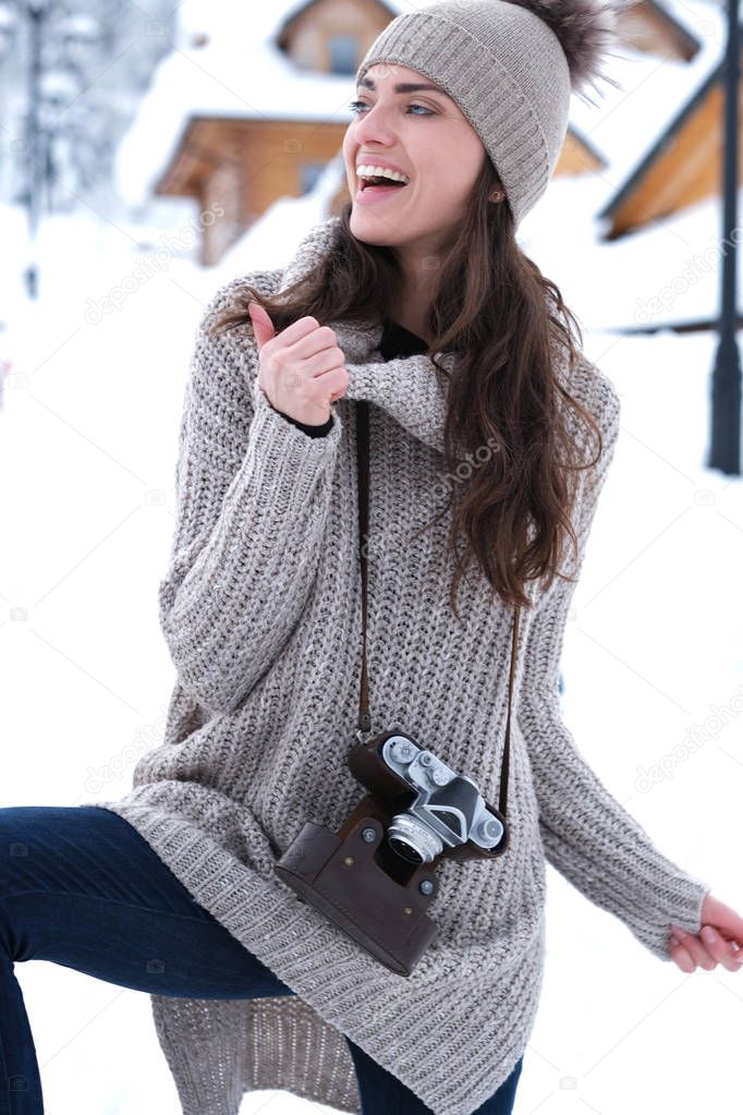 Beautiful girl taking a picture in the mountains. Winter season.