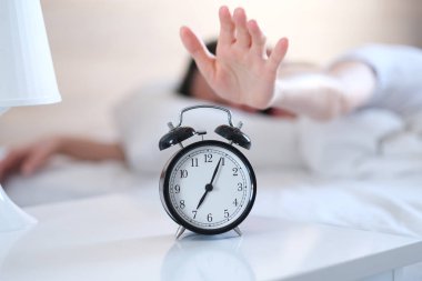 Genç kadın uyanmak hazır değil. Çalar saat. Kalkma zamanı.