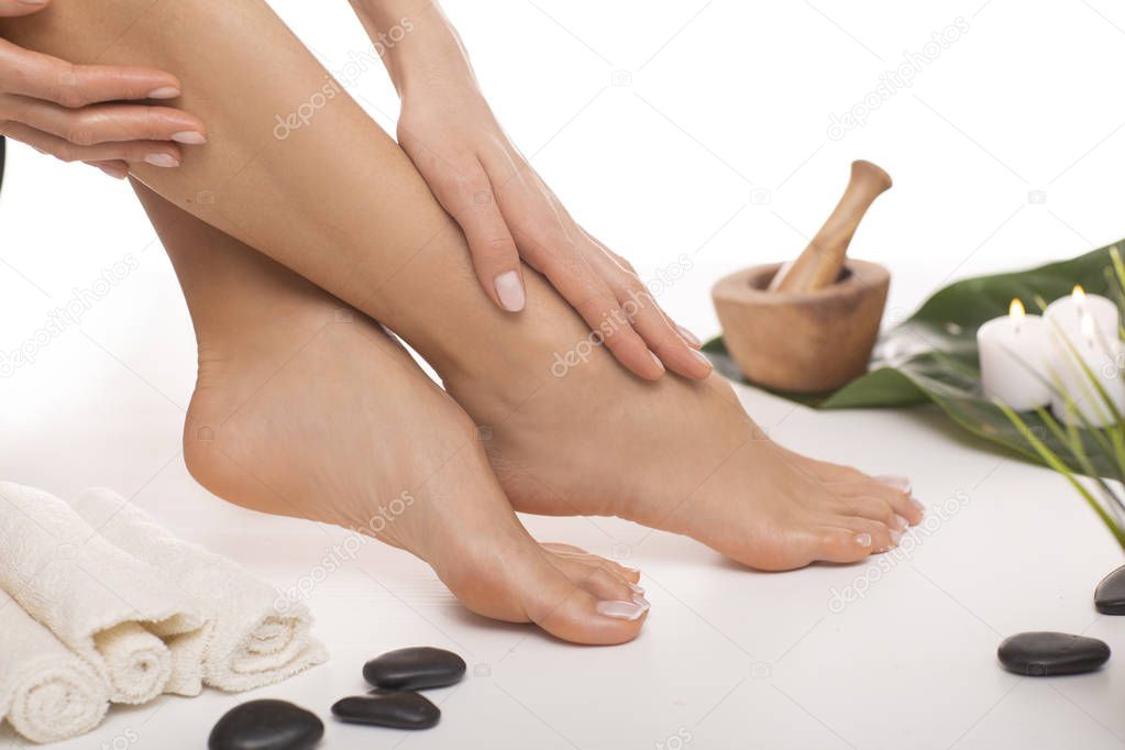 The picture of ideal done manicure and pedicure. Female hands and legs in the spa spot in the white background.