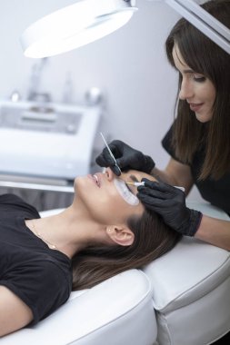 Güzel kadın kirpik yaparken bir güzellik salonu. Kirpik uzatma