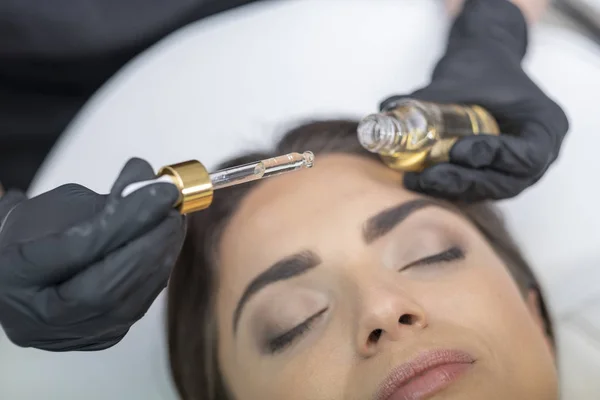 美容师正在在移液器中涂黑发化妆品 — 图库照片