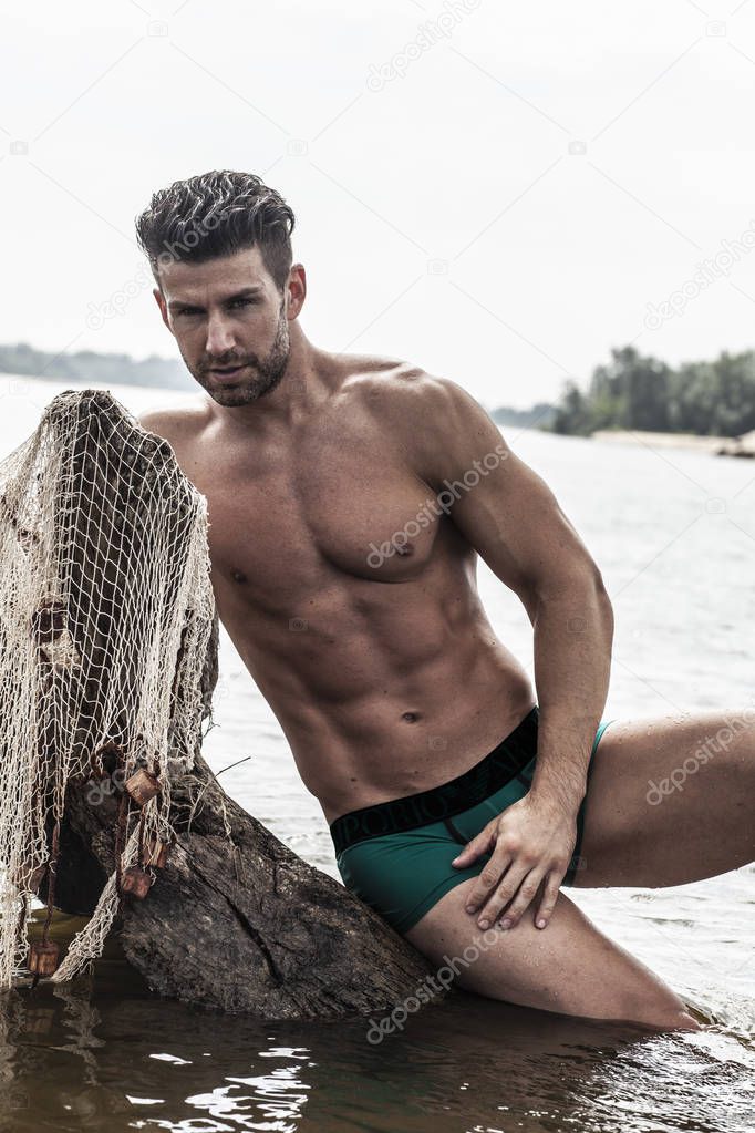 Sexy, muscular man on the beach.