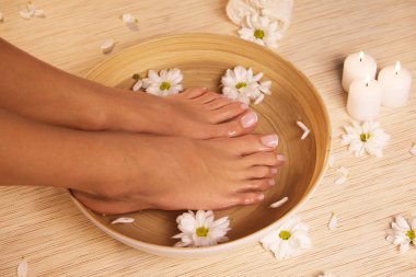 İdeal yapılan manikür ve pedikür resmi. Kadın ellerde ve spa noktada.