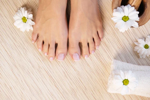 Female hands and legs at the bamboo mat.