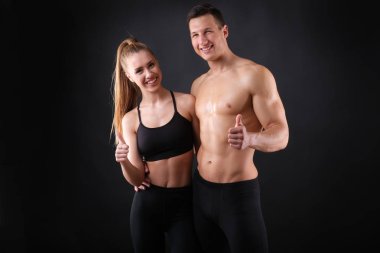 Fitness genç adam ve kadın siyah arka planda izole.