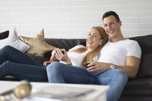 Young couple spending time together at home drinking coffee and talking.