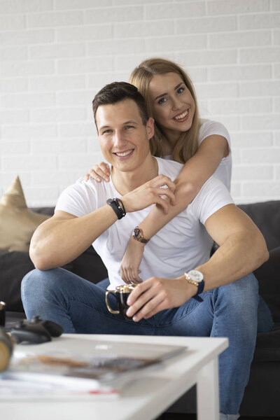 Young couple spending time together at home drinking coffee and talking.