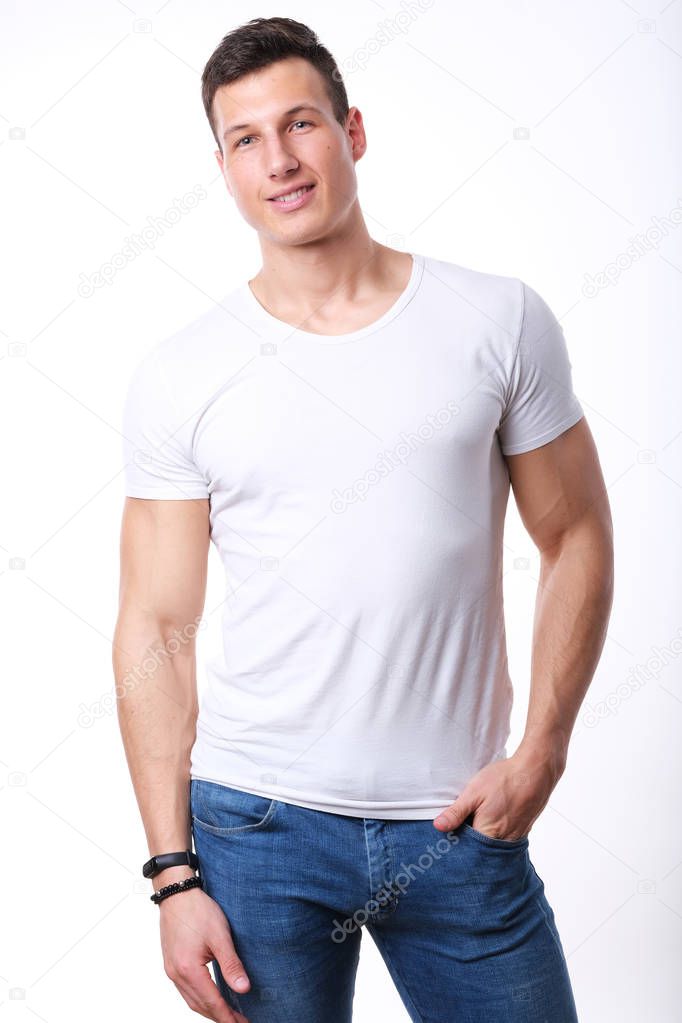 Studio shoot of young sport man in white shirt and jeans. 