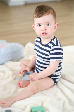 Bebek Çocuk yerde Ahşap oyuncaklar ile oynuyor.