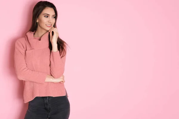 ピンクの背景にピンクのセーターのポーズのエネルギーでいっぱいのかなり若い女の子 — ストック写真