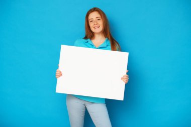 Zencefil kız mavi arka plan üzerinde bir beyaz tahta tutan.
