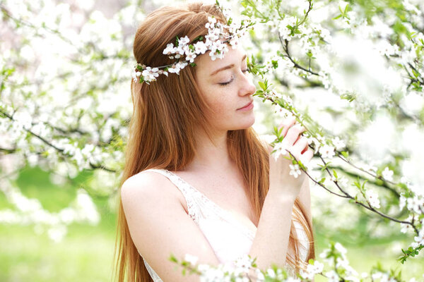 Beauty romantic woman portrait in blooming trees