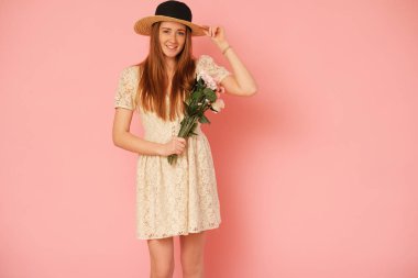 Hasır şapka ve çiçek buketi ile güzel, pastoral kız.