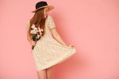 Hasır şapka ve çiçek buketi ile güzel, pastoral kız.