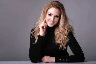 Gri arka planda nazik bir gülümseme ile güzel kadın.