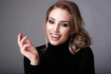 Gri arka planda nazik bir gülümseme ile güzel kadın.