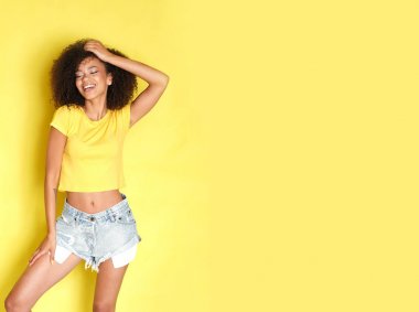 Mutlu afro model çekim sırasında gülüyor ve yan bakıyor