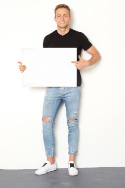 Elinde beyaz tahta ile genç yakışıklı model.