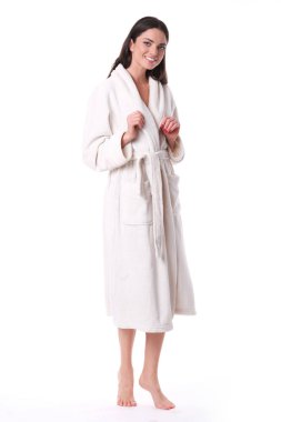 Beyaz arka planda duran beyaz bornozlu model.