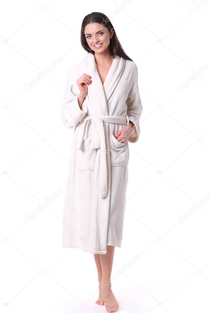 Studio shoot of model in white bathrobe looking down.