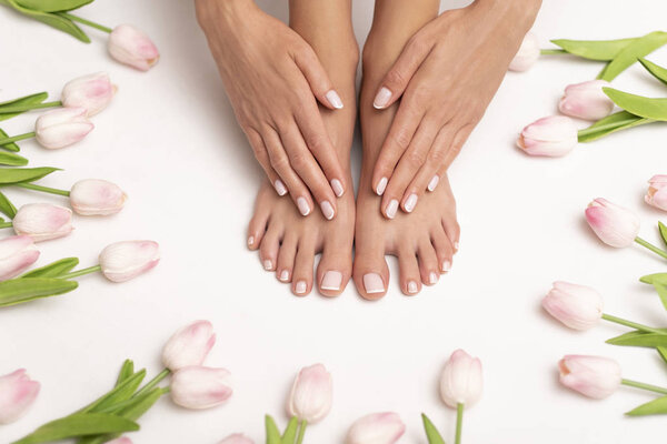Female hands and feet with perfect done pedicure.