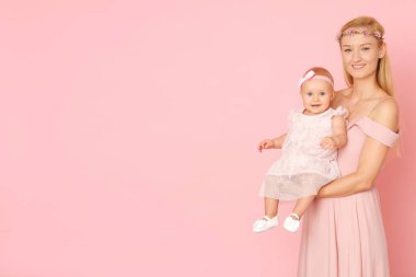 Tören pembe elbiseler güzel anne ve onun küçük kızı.