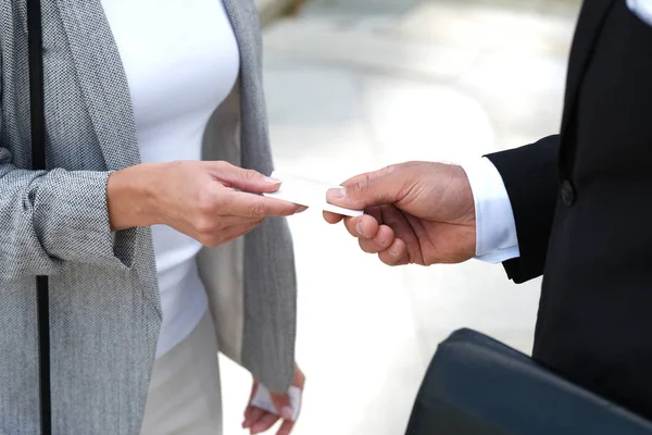 Businessman is giving a business card to a woman.