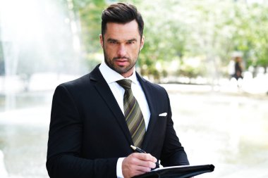 Klasik siyah takım elbiseli zarif adam bir iş toplantısı için hazırlanıyor.