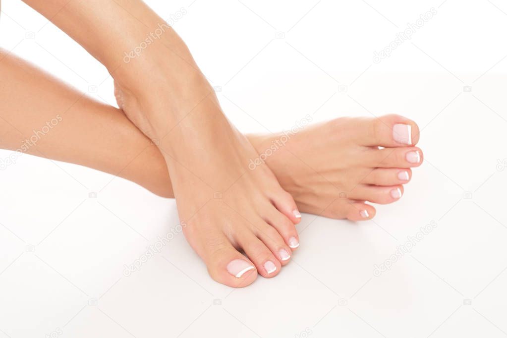 Tiny, female feet with delicate skin and perfectly done pedicure.