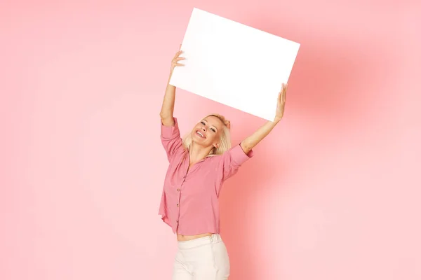 Mulher Loira Camisa Rosa Está Segurando Banner Branco Com Informações — Fotografia de Stock