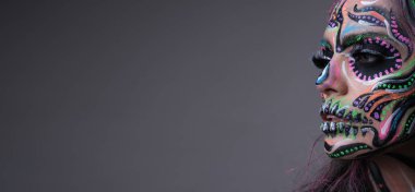 Gri arka planda izole edilmiş korkunç makyaj modeli.