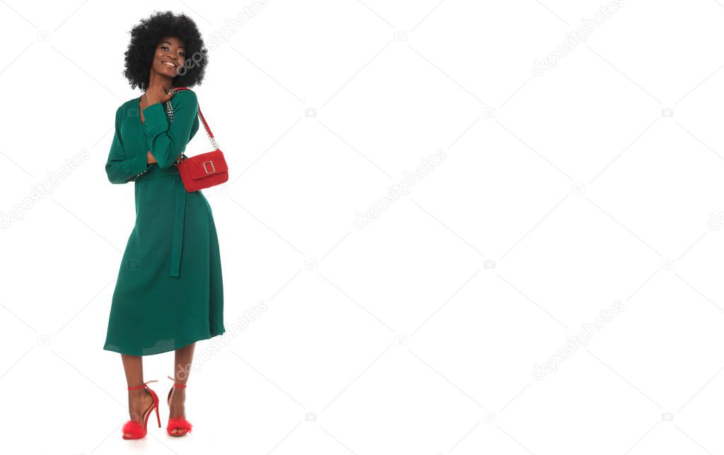 Perfect, total look of happy african woman in green dress and red accessories.