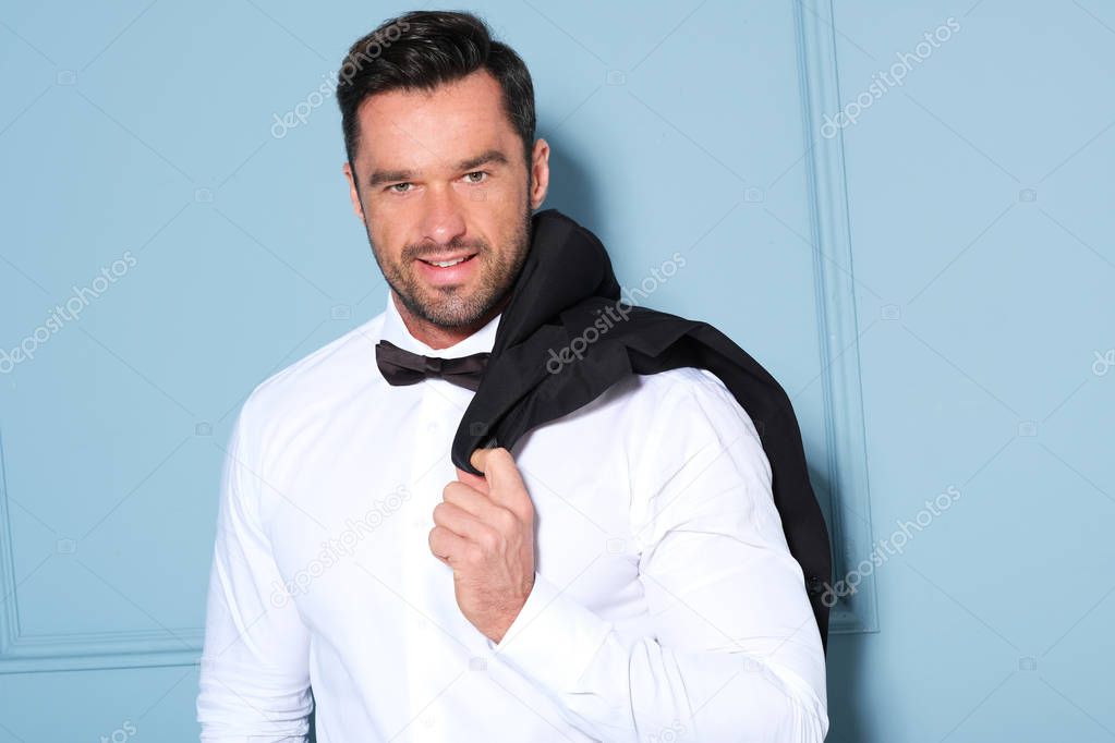 Handsome man in white shirt with classic black bow-tie.