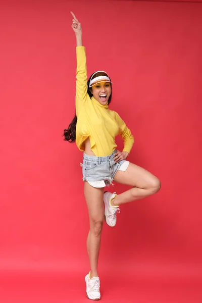 Energetic studio shoot. Asian model full of charisma and good energy wearing yellow clothes. Colorful shoot.