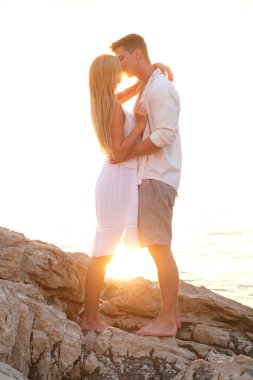 Çok romantik anlar. Genç çift, gün batımı ve deniz..
