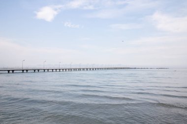 Açık su ve mavi gökyüzü ile denizde huzurlu bir yaz günü martılar ile bir iskelenin güzel görünümü