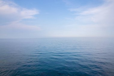 Huzurlu bir yaz gününde açık mavi gökyüzü ve sakin denizin güzel arka planı