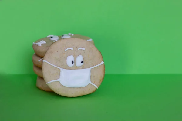 Galletas redondas sobre un fondo verde, galletas de azúcar, máscara médica hecha de glaseado blanco — Foto de Stock