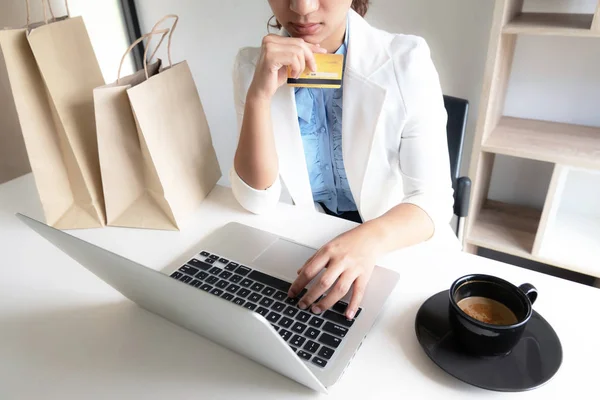 喫茶店でのオンラインショッピングにクレジットカードを持ち、ノートパソコンを使うビジネスウーマンオフィスリーダーのイメージ — ストック写真