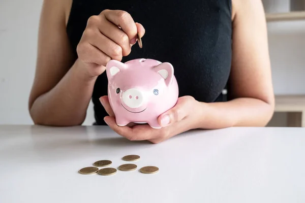 Woman in black shirt teach kits to putting Coin In pink Piggy Bank, step up growing business to success and saving for retirement concept