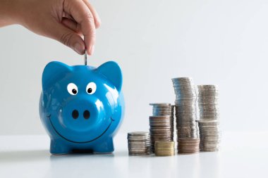 el sikke yığını ile mavi kumbara koyarak, başarı ve emeklilik kavramı için tasarruf büyüyen iş hızlandırmak