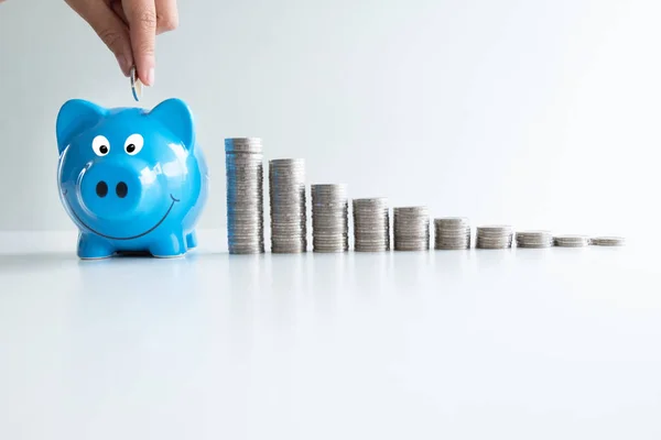 Hand putting munt in blauwe Piggy met munten grafiek, stap omhoog groeiend bedrijf naar succes en besparing voor pensioen concept — Stockfoto