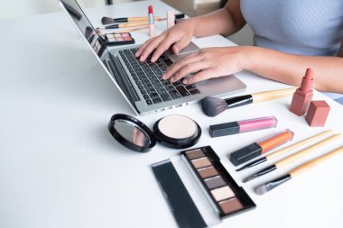 kadın Blogger mevcut kozmetik ürün ön tablet oturan ve internet tarafından sosyal ağa yayın, güzellik blogger online pazarlama kavramı