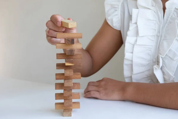 woman playing blocks wood game, gambling placing wooden block. Concept Risk of management and strategy plan, growth business success process