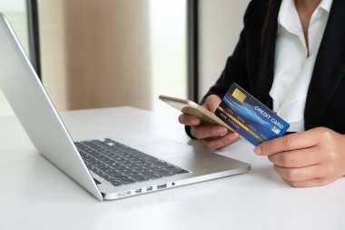 Online alışveriş ve ödeme için iş kadını tüketici Holding kredi kartı ve akıllı telefon Internet üzerinde bir satın alma yapmak